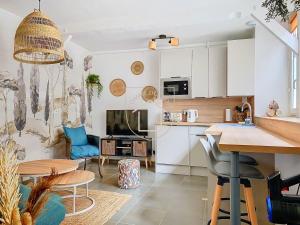 a kitchen and living room with a table and a couch at La Cachette des Rois in Dourdan