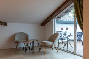 a room with chairs and a table and a balcony at Hotel & Restaurante El Casino in Villafranca del Bierzo