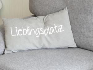 a white pillow sitting on a gray couch at Haus Budinger in Alf