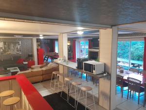 a kitchen and living room with a counter and chairs at Chambre liberté in Condé-sur-Noireau