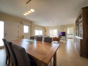 a dining room and living room with a table and chairs at Frontline Beach Villa Playa Flamenca in Orihuela