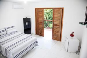 1 dormitorio con 1 cama y puerta abierta en Mandacaru Flat, en São Miguel do Gostoso