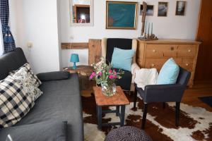 un soggiorno con divano e tavolo con fiori di 4 Elements Appartmenthaus Monarda a Flachau