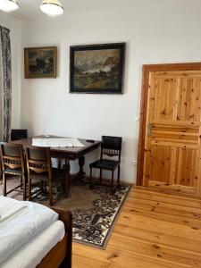 バンスカー・シュチャヴニツァにあるApartmány Perlaのテーブルと椅子、ドアが備わる部屋