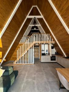an attic room with a wooden ceiling and a staircase at Mareva House Căsuțe A frame Chalet in Râmnicu Vâlcea