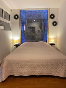 a bedroom with a large bed and a large window at La Roche - Studio 2 étoiles Eco Responsable avec Tv Connectée in Maury