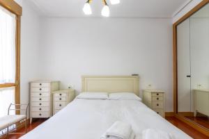 a bedroom with a large white bed and two dressers at Bilbao BEC with parking by Aston Rentals in Barakaldo +14 photos