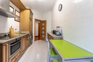 a large kitchen with a green counter top at Bilbao BEC with parking by Aston Rentals in Barakaldo