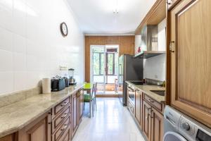 a kitchen with wooden cabinets and a counter top at Bilbao BEC with parking by Aston Rentals in Barakaldo