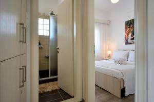 a bedroom with a bed and a door leading to a bathroom at Villa del Capitano in Corfu Town