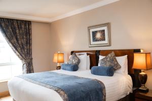 a bedroom with a large bed with two lamps at The Villa Rose Hotel & V-Spa in Ballybofey