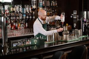 a bartender making a drink at a bar at The Villa Rose Hotel & V-Spa in Ballybofey