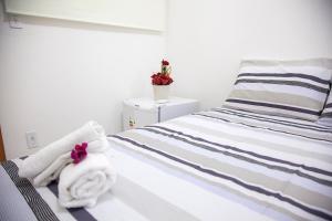 a bedroom with a bed with towels on it at Mandacaru Flat in São Miguel do Gostoso