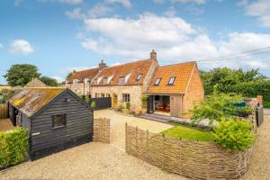 an exterior view of a house with a fence at Monarc House by Big Skies Cottages in Baconsthorpe
