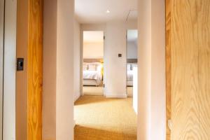 a hallway leading to a bedroom with a bed at Monarc House by Big Skies Cottages in Baconsthorpe
