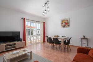a living room with a table and chairs and a television at Abelisa by An Island Apart in Porto Santo