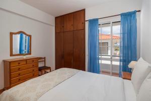 a bedroom with a bed and a mirror and a window at Abelisa by An Island Apart in Porto Santo +16 photos