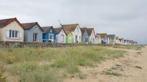 a row of colorful houses on the beach at Le Neptune in Sainte-Mère-Église
