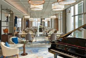 a lobby with a piano and chairs and tables at VIE Hotel Bangkok - MGallery Collection in Bangkok +44 photos