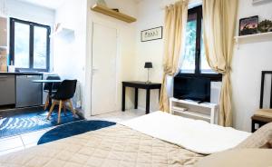a bedroom with a bed and a desk and a tv at Joli Studio Joinville bord de marne 15m de Paris in Joinville-le-Pont