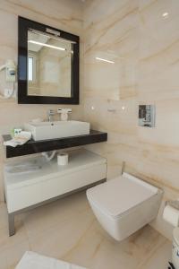 a bathroom with a sink and a toilet and a mirror at Sole Luna Hotel in Borsh
