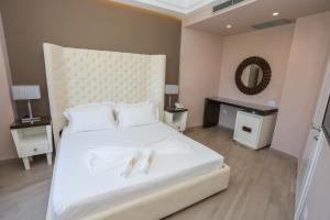 a bedroom with a large white bed and a mirror at Sole Luna Hotel in Borsh
