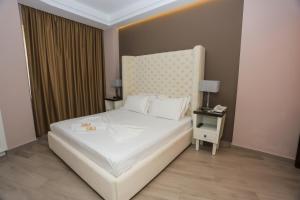 a bedroom with a white bed and a side table at Sole Luna Hotel in Borsh