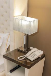 a phone on a table with a lamp on it at Sole Luna Hotel in Borsh