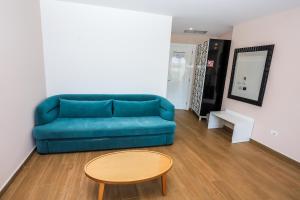 a living room with a blue couch and a table at Sole Luna Hotel in Borsh