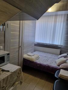 Un dormitorio pequeño con una cama y una ventana. en Luxury boutique, en Chişinău