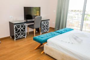 a bedroom with a bed and a desk and a television at Sole Luna Hotel in Borsh