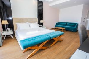 a bedroom with a large bed and a blue couch at Sole Luna Hotel in Borsh
