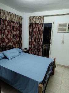 a bedroom with a bed with blue sheets and a window at apartment b1 AL2 in Madinaty +3 photos