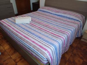 a bed with a striped blanket on top of it at La casa sotto al volto in Licciana Nardi