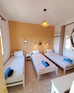 a room with three beds in a room at Stafylos Rooms in Stafylos
