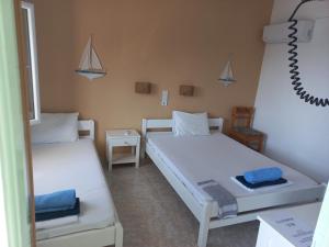 a room with two beds and a mirror at Stafylos Rooms in Stafylos