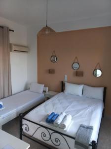 a bedroom with a bed with two blueippers on it at Stafylos Rooms in Stafylos