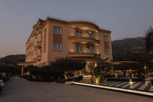 a large building with a parking lot in front of it at Sole Luna Hotel in Borsh