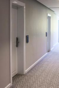 an empty hallway with two doors and a tile floor at Sole Luna Hotel in Borsh