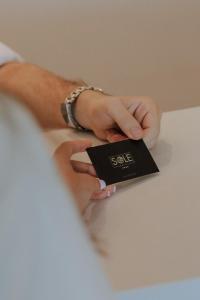 a person holding a card in their hands at Sole Luna Hotel in Borsh