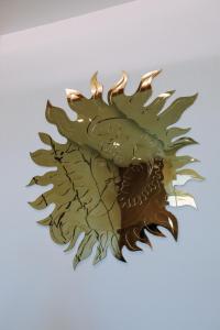 a wooden sun sculpture on a white background at Sole Luna Hotel in Borsh