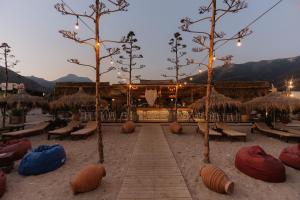 a resort with chairs and trees in the sand at Sole Luna Hotel in Borsh