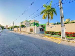 an empty street with a palm tree and a building at Ap 2 quartos espaçoso in Natal
