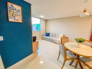 a living room with a table and a blue wall at Ap 2 quartos espaçoso in Natal