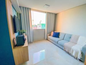 a living room with a couch and a television at Ap 2 quartos espaçoso in Natal
