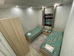 a small room with two beds in it at Laguna City in Tegirmenty