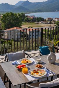 a table with plates of food on top of a balcony at Hotel AQUILO in Petrovac na Moru