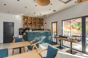 a kitchen and dining room with tables and chairs at Hotel AQUILO in Petrovac na Moru