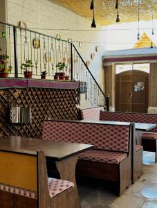 a restaurant with a bench and a table and stairs at BESQALA in Nukus