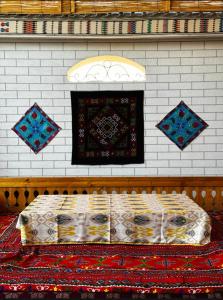 a bed in a room with a wall at BESQALA in Nukus